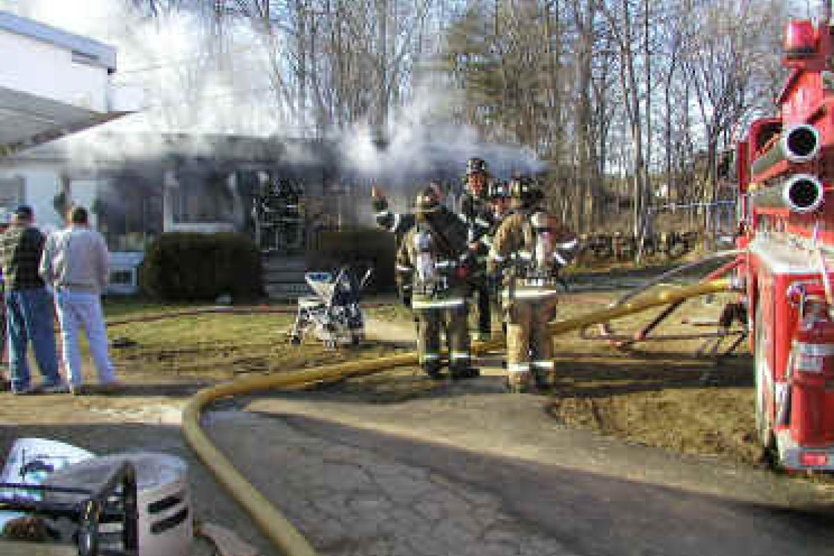 Firemen standing in a group at scene of a fire