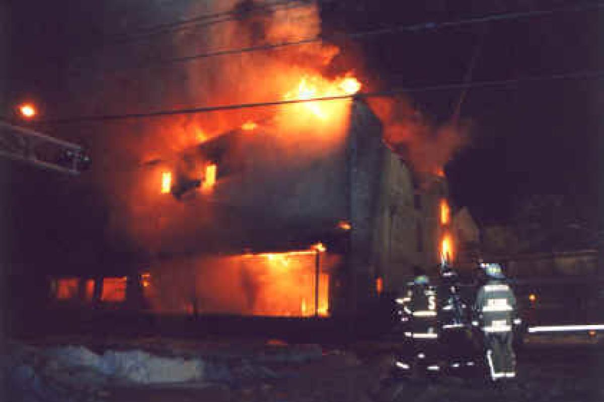Fire Apparatus at scene of a fire - building engulfed in flames