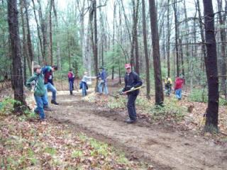 A group of volunteers does work on the Pond Loop trail